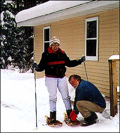 Photo. Jerri has her snowshoes adjusted by Chuck