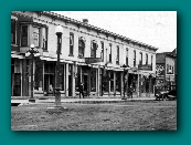 C. F. Kent pharmacy in front of auto, DeWitt, Iowa main street about 1910